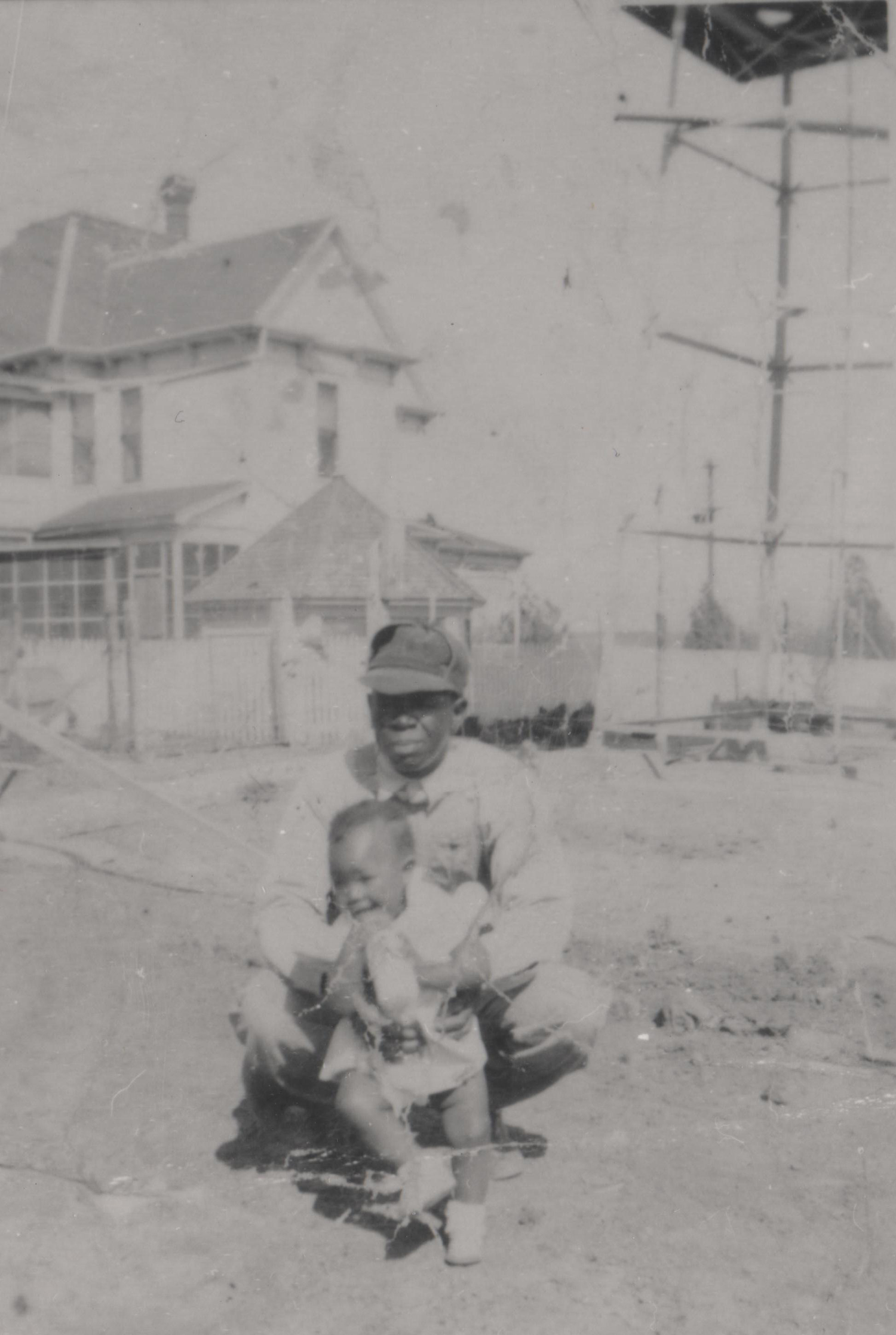 The Farrell-Wilson house behind caretaker Ernest Sanders and his daughter Ammie (named after Ammie Wilson), circa 1940