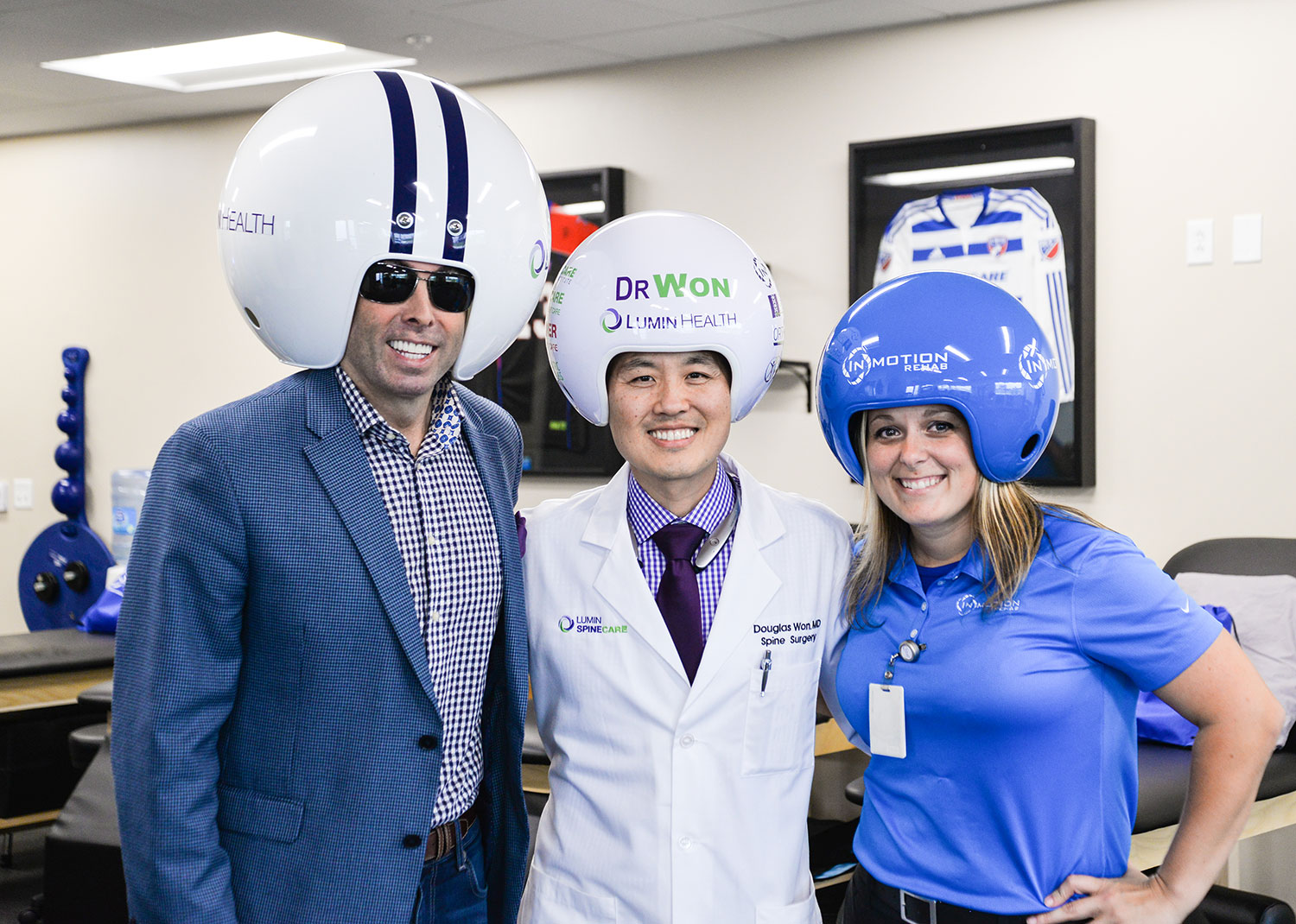 Spine surgeon and CEO of Lumin Health, Dr. Douglas Won (center), is pictured with Gregg "Wreckin' Ball" Wilson and Michelle Zammit, rehab and durable medical equipment director, in the InMotion Rehab of Lumin Health Center in Plano. Mr. Wilson is the inventor of the customizable Wreckin’ Ball Helmets.