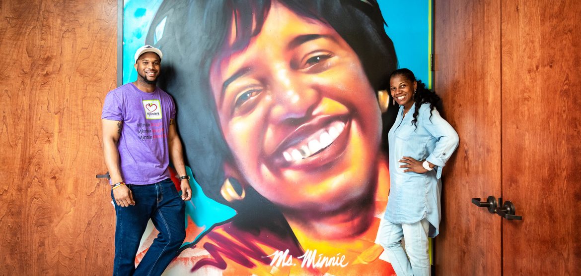 Cheryl Jackson and her son R.J. Jackson in front of the painting of Minnie Ewing, the namesake of Minnie's Food Pantry // photo Jennifer Shertzer