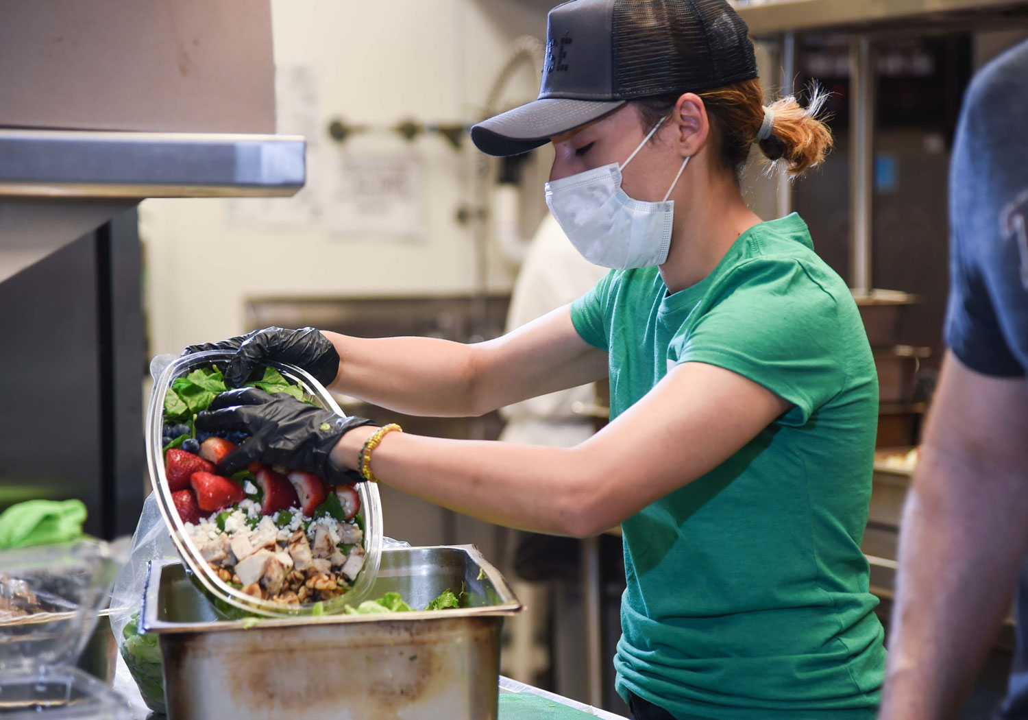 Volunteer Rosa Mendoza helps prepare a salad as part of the 800 meals OurCalling serves to those in need each weekday // courtesy of Klekamp Group