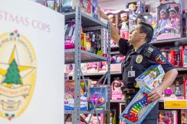Plano Police Officer Isaac Soto sorts toys for Christmas Cops // photos Jennifer Shertzer