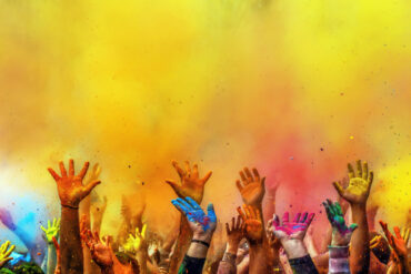 Hands painted with different colors raised up on Holi festival