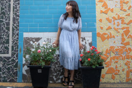 Author Lyla Lee in font of a blue wall. Photography by CJ Lee