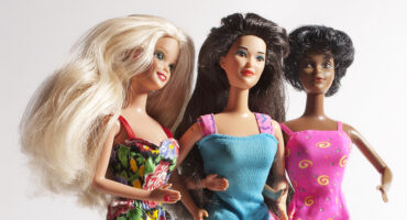 A studio shot of three vintage Barbie dolls of different ethnicity. Barbie dolls are have been manufactured by Mattel, Inc. since1959.