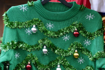 Getty image of ugly sweater with green garland and ornaments