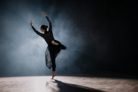 Backlit shot of rear view of young ballerina rehearsing on the stage Getty image