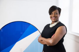 Junior League of Collin County President Shun Thomas near blue circular sculpture. Photography by Kathy Tran.