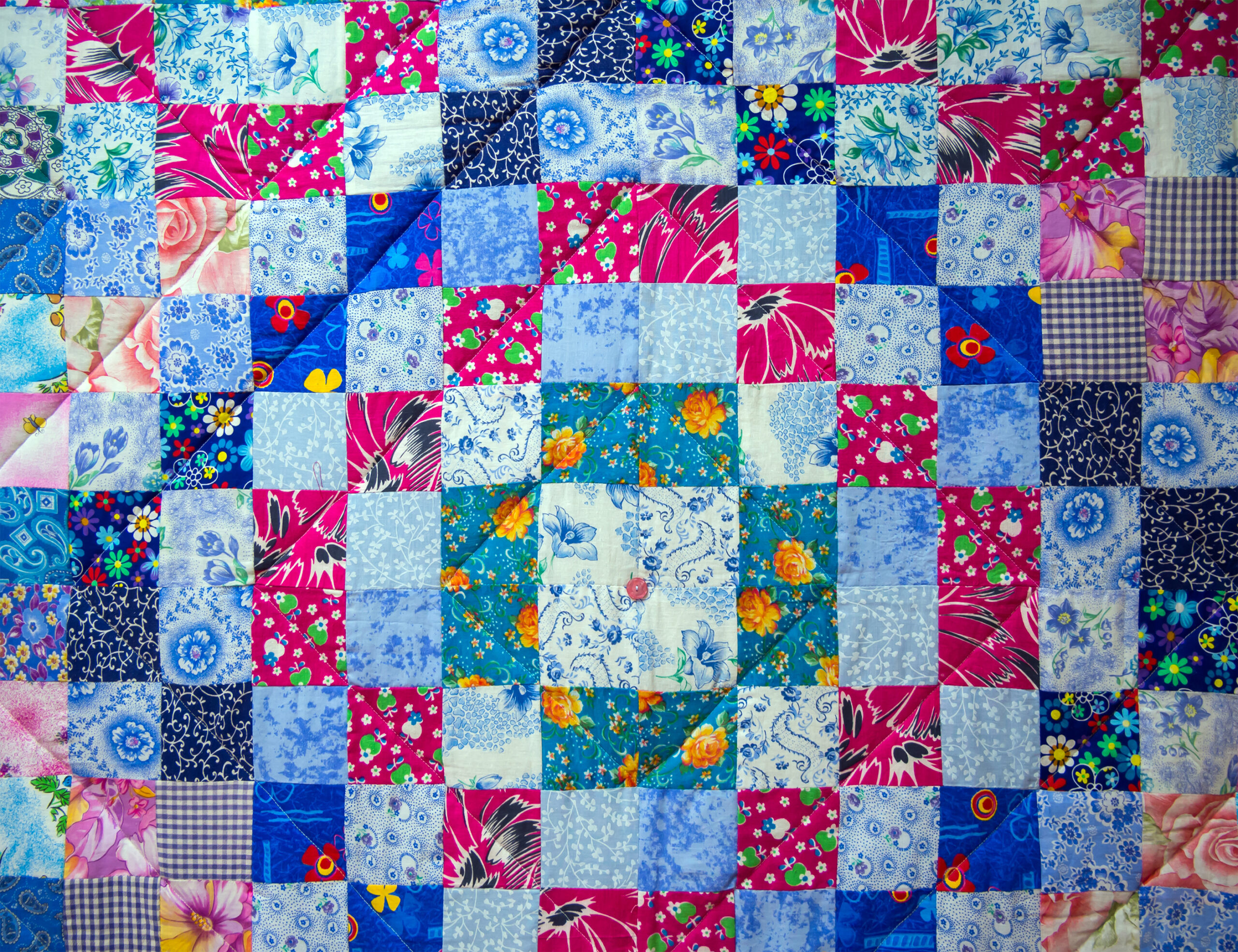 Quilt made of multi-colored fabric rectangles in patchwork style.